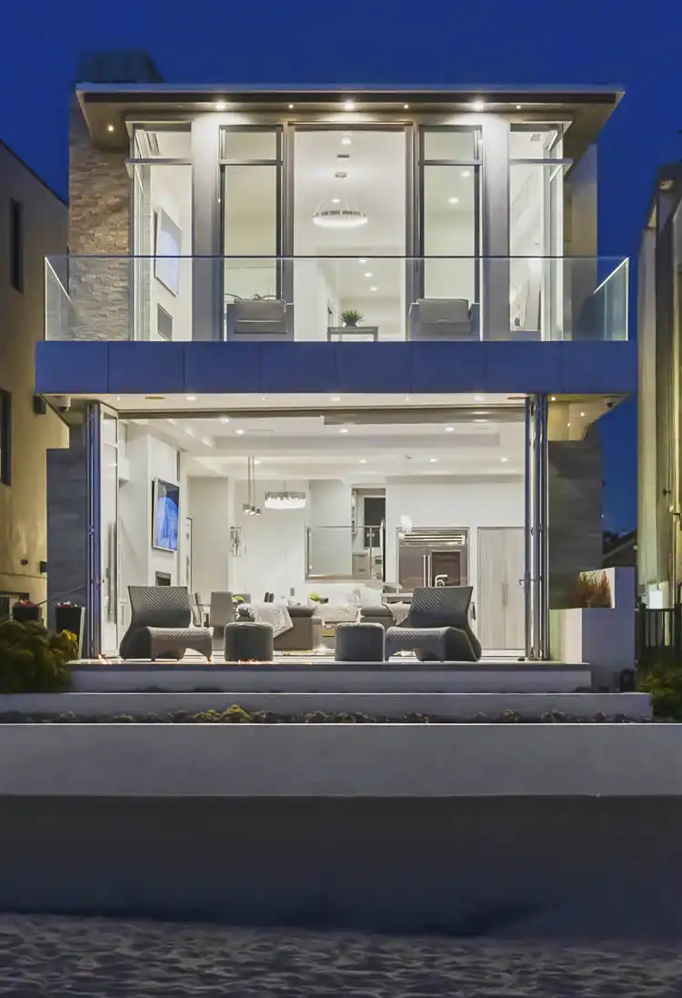 Luxury beachfront home exterior with glass walls and open living area