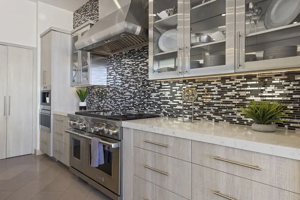 Luxury kitchen with stainless steel appliances and mosaic backsplash at 212 The Strand