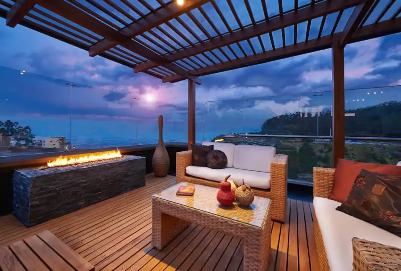 ocean-view-pergola-deck-wicker-fire-pit-sunset Ocean-view pergola deck with wicker seating and linear fire pit at sunset